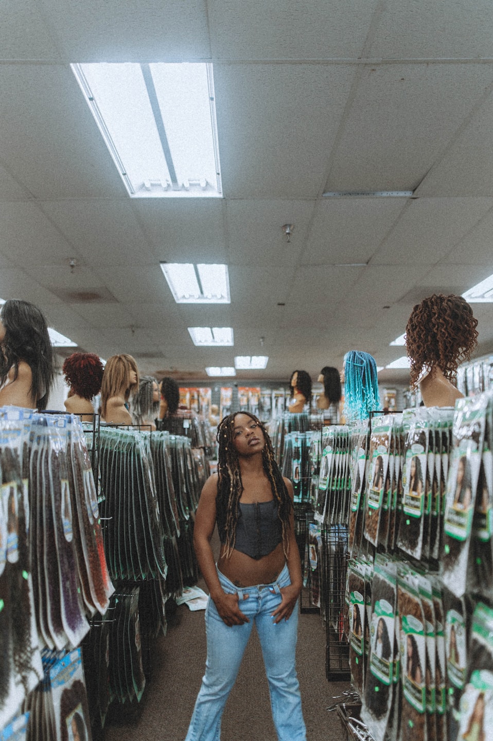 Woman browsing hair extensions in a beauty supply store.